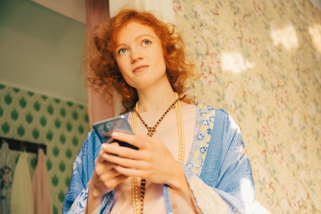 Young woman in bathroom with mobile SMALL